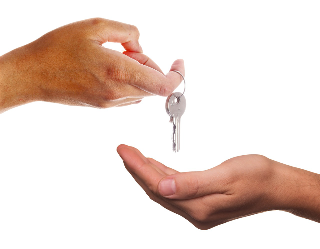 Two hands are exchanging keys