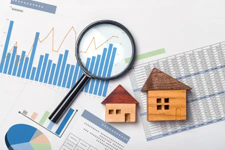 A magnifying glass over financial charts with real estate data, symbolizing NYC market predictions for 2025.